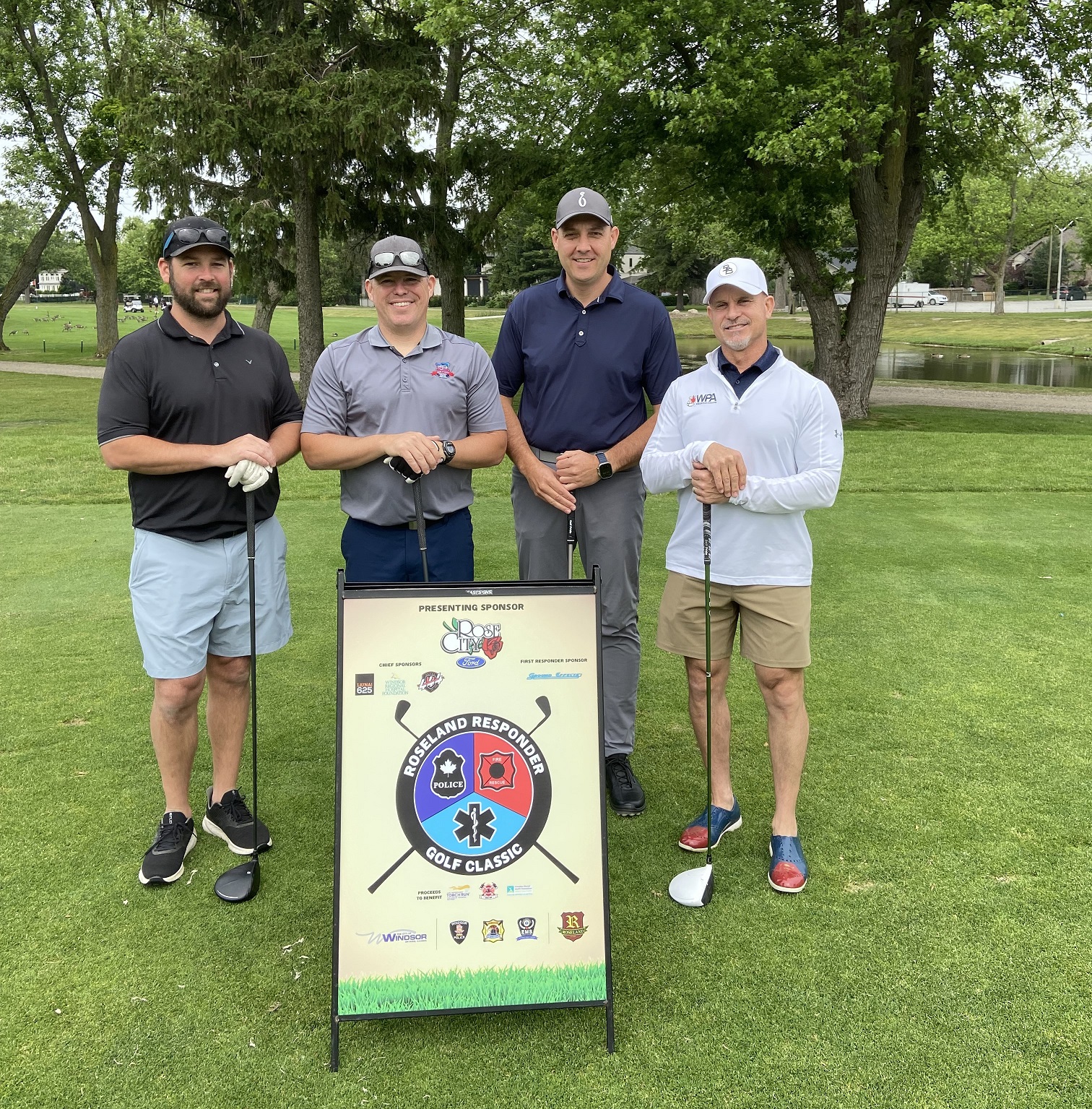 Winning foursome in front of tournament sign