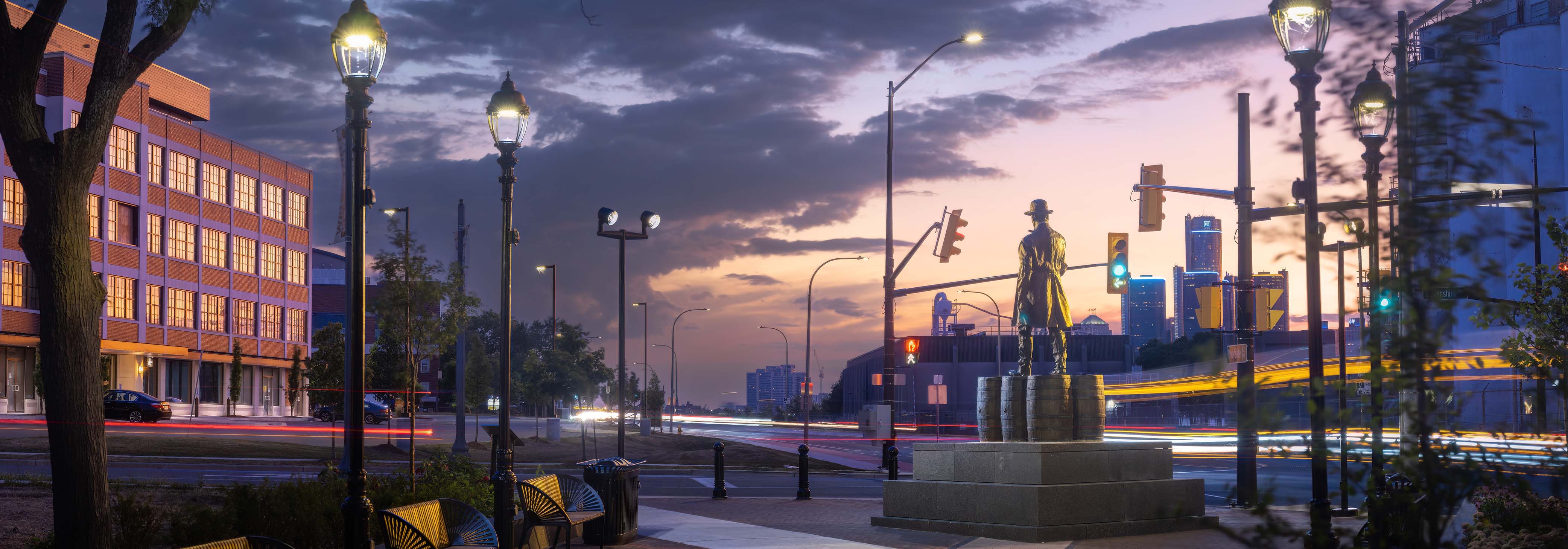 Hiram Walker bronze sculpture in a park, photographed at sunset