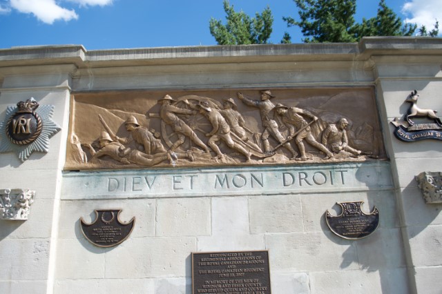Detail of a limestone and bronze monument highlighting the bronze relief elements.