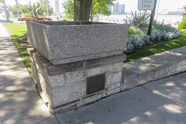 Small plaque at ground level mounted into masonry.
