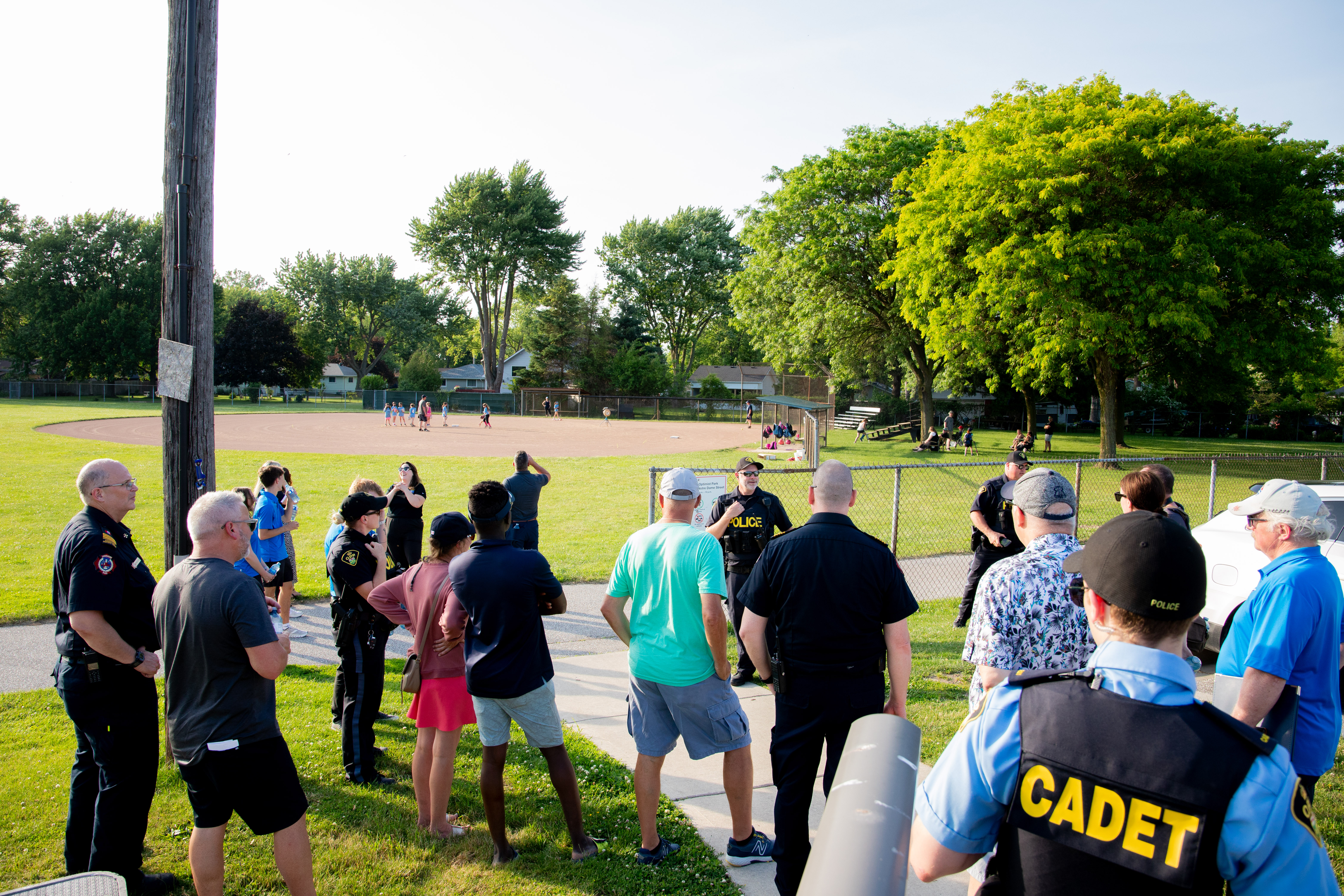June 17, 2025 Lakeshore Neighbourhood Safety & Crime Prevention Walk A group of residents and police officers gathered outside at a park